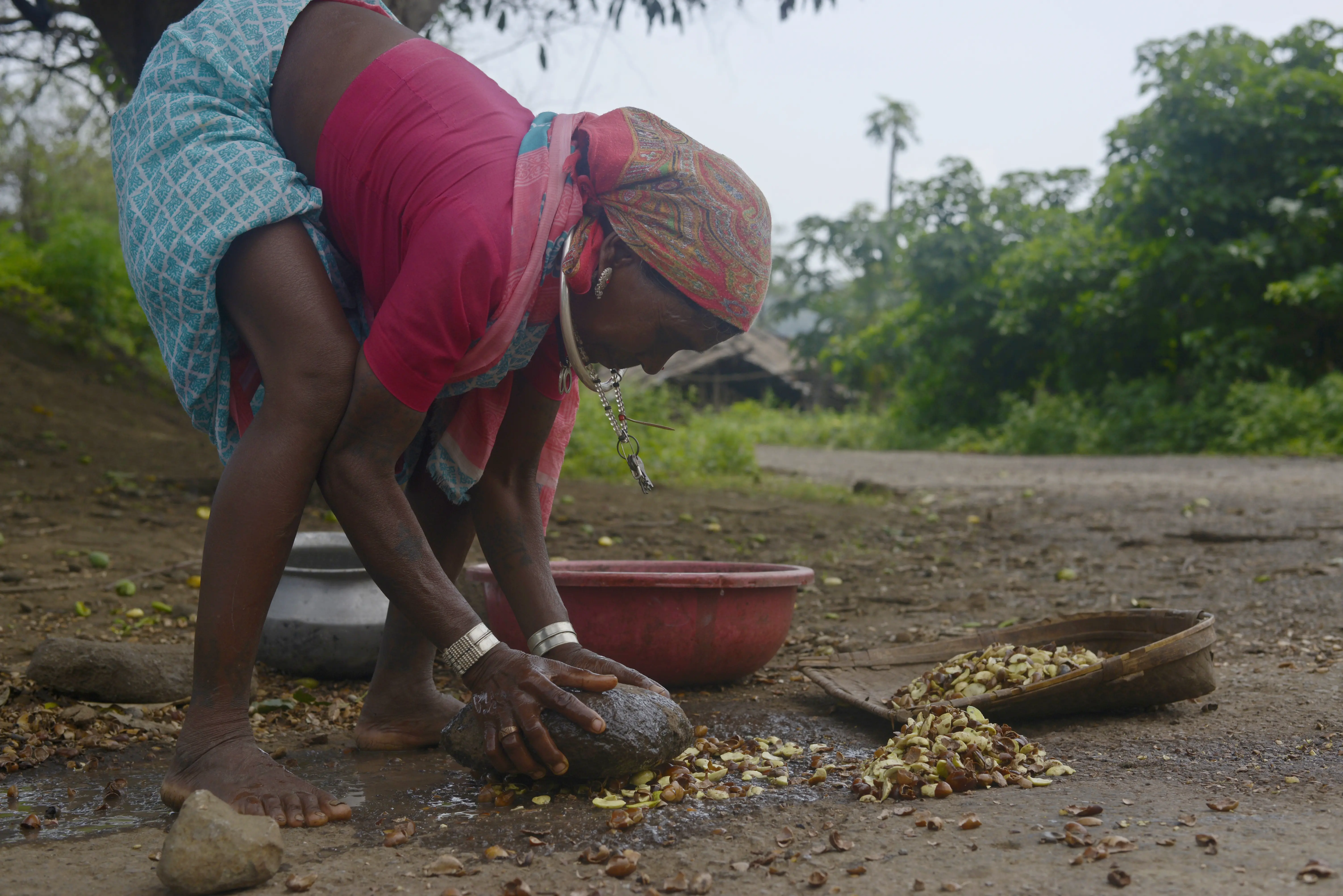 A woman works on extracting oil from a mahua fruit 