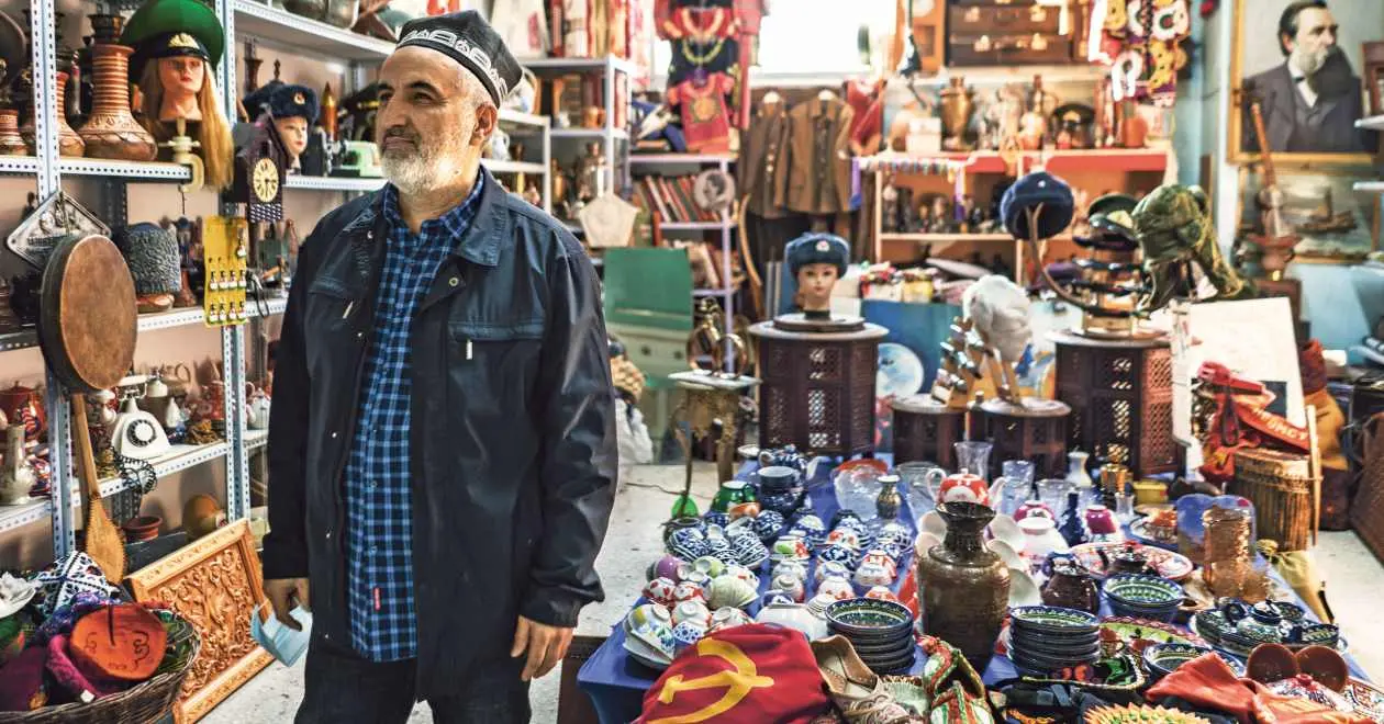 A man stands in front of his shop where he sells small Soviet paraphernalia