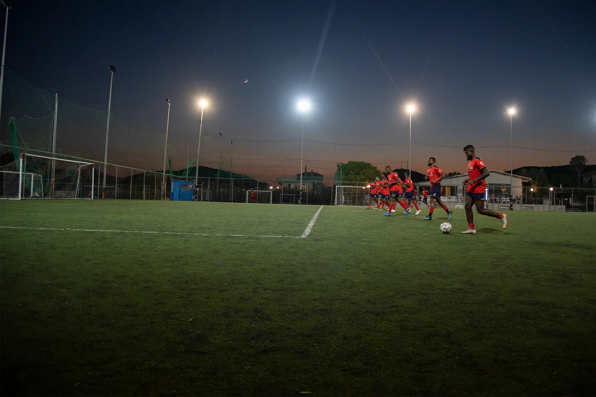 team on soccer field at night