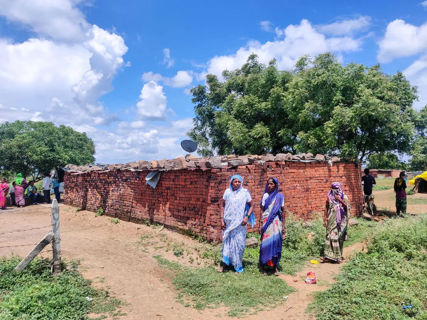 Women walk through hut