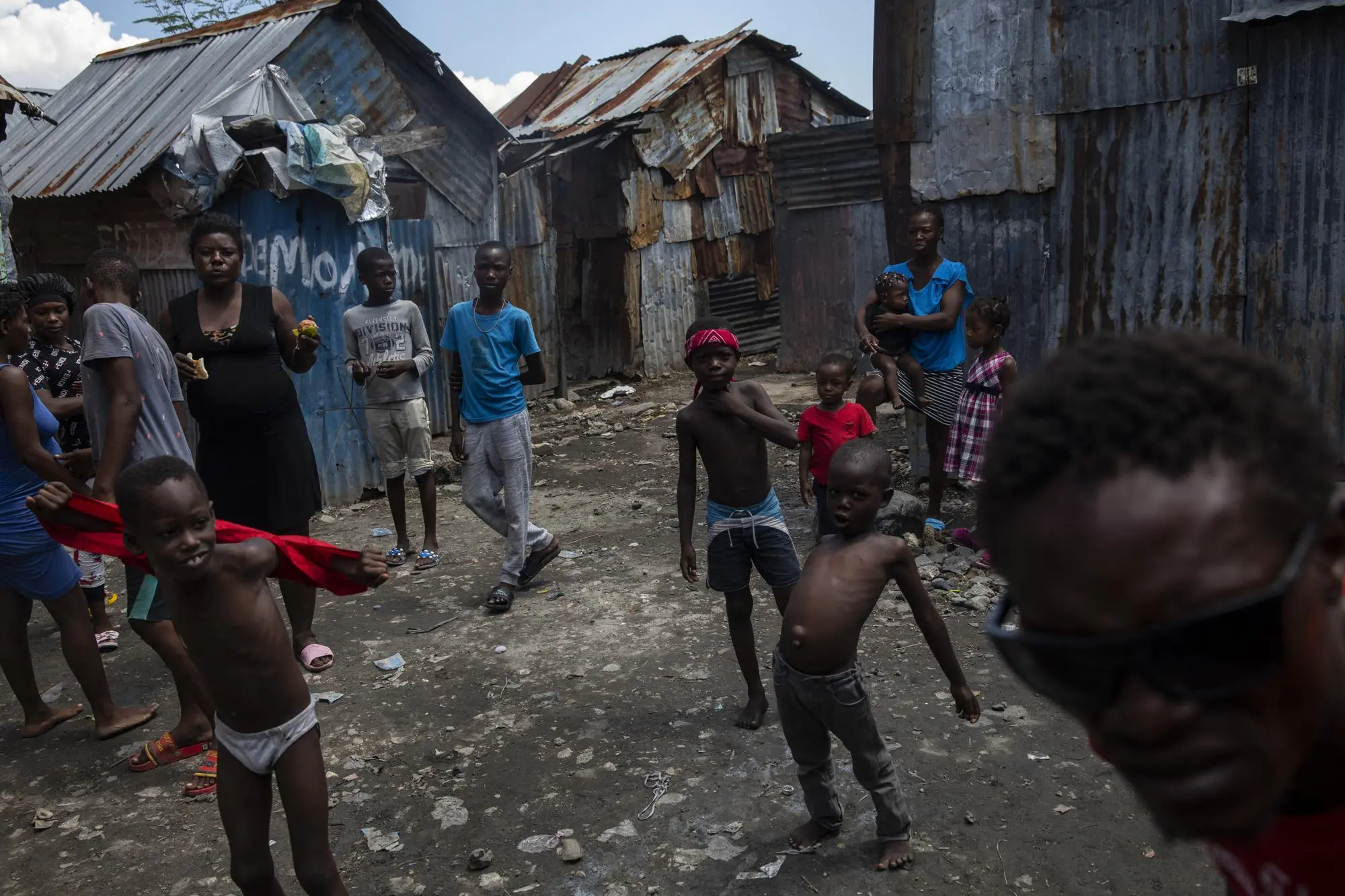 Neighbors gather outside their homes built with recycled metal sheets