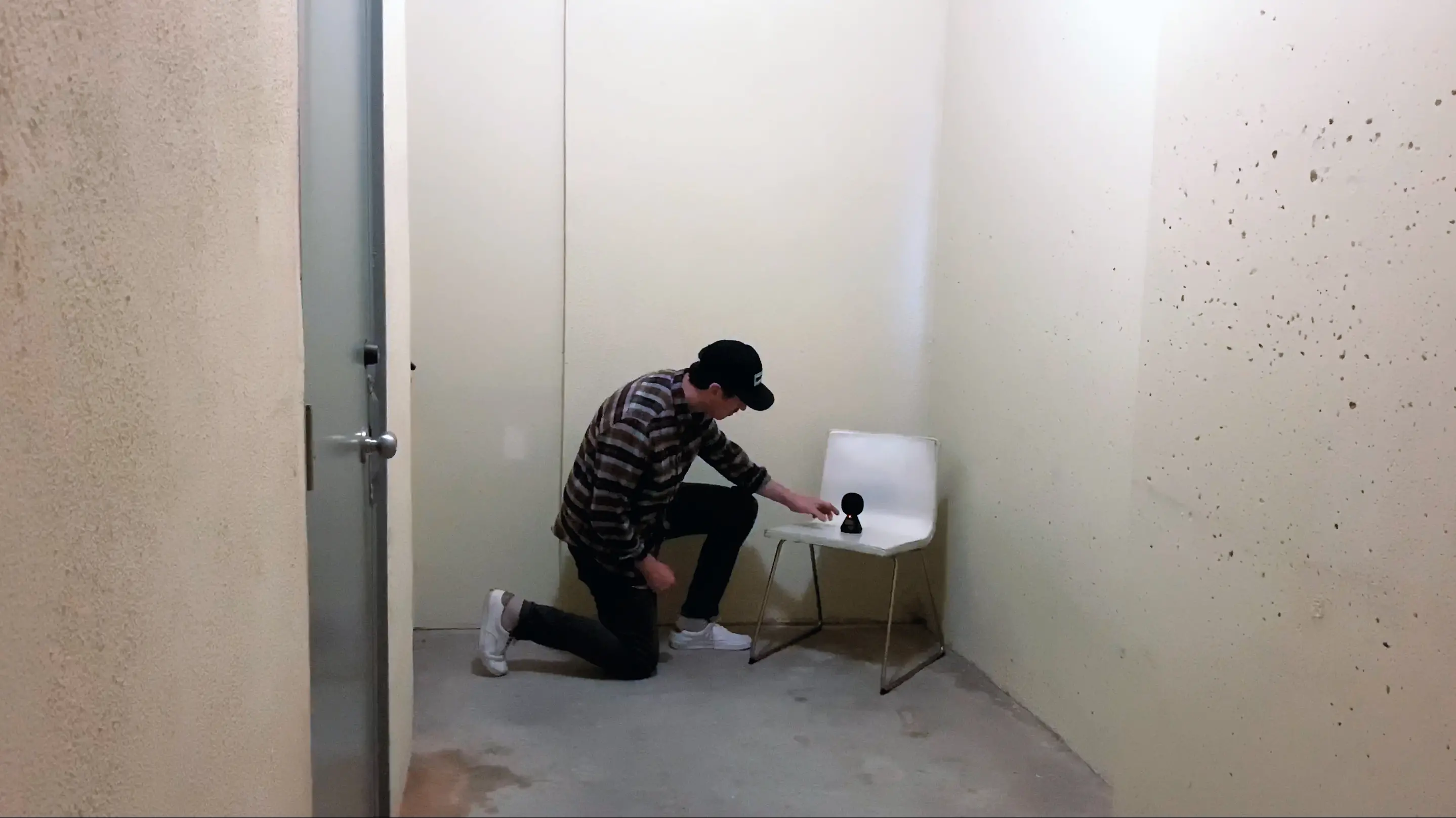 Someone places a device on a white chair.