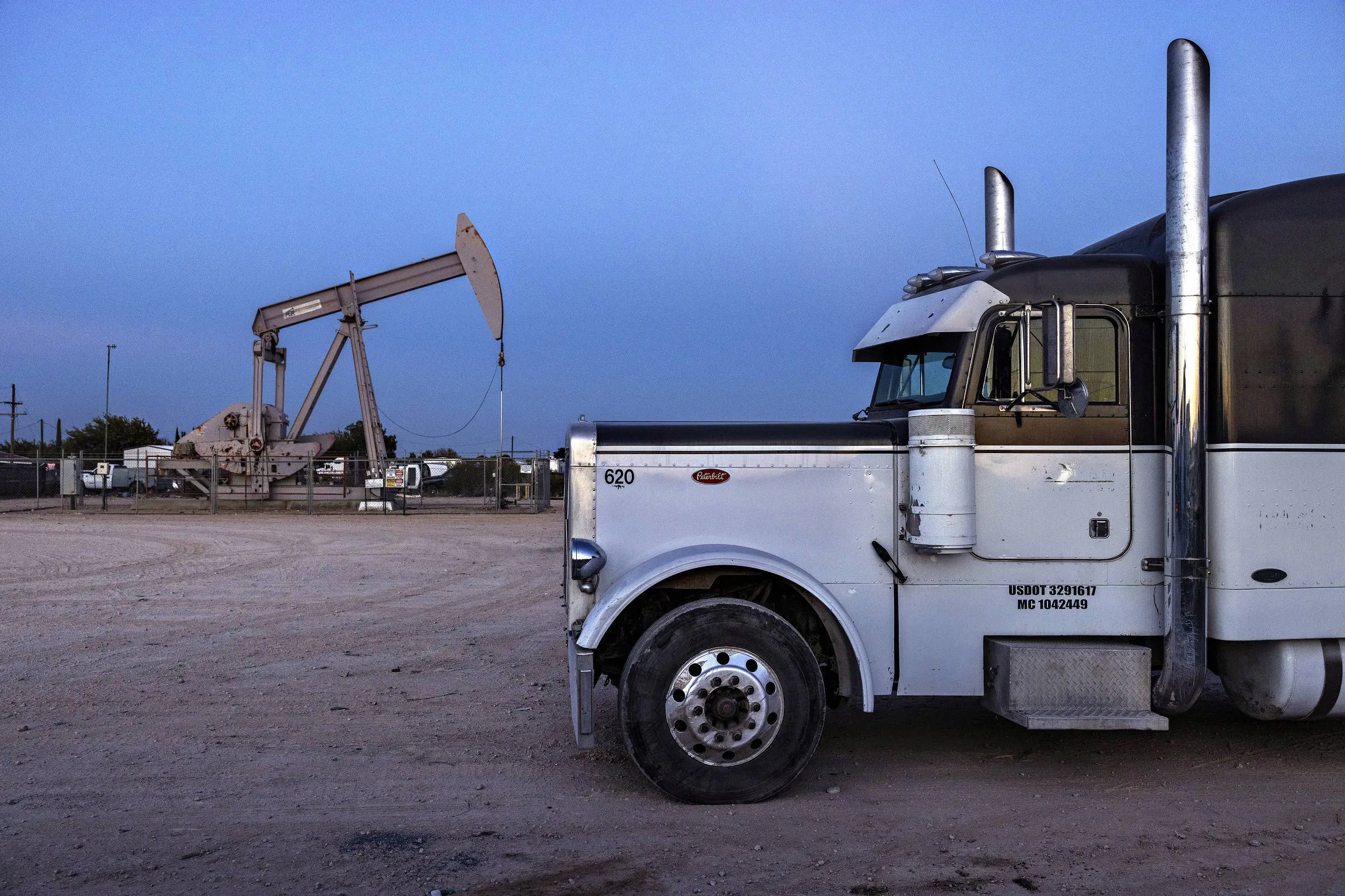 Oil extraction well next to a truck parking lot near the city of Odessa, Texas.