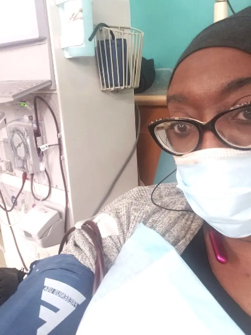 Photo of Stephanie in a medical face mask and next to medical equipment.