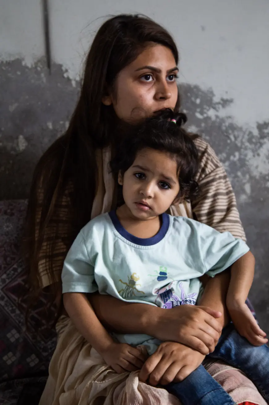 a woman sits with a young family member on her lap