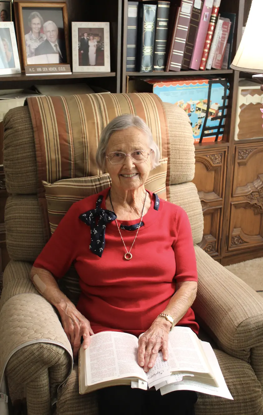 woman sits in chair with bible