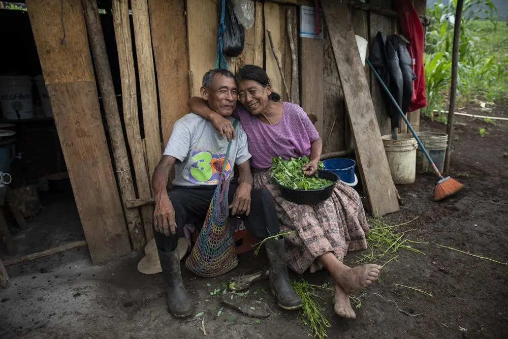 Couple sits together in front of their home