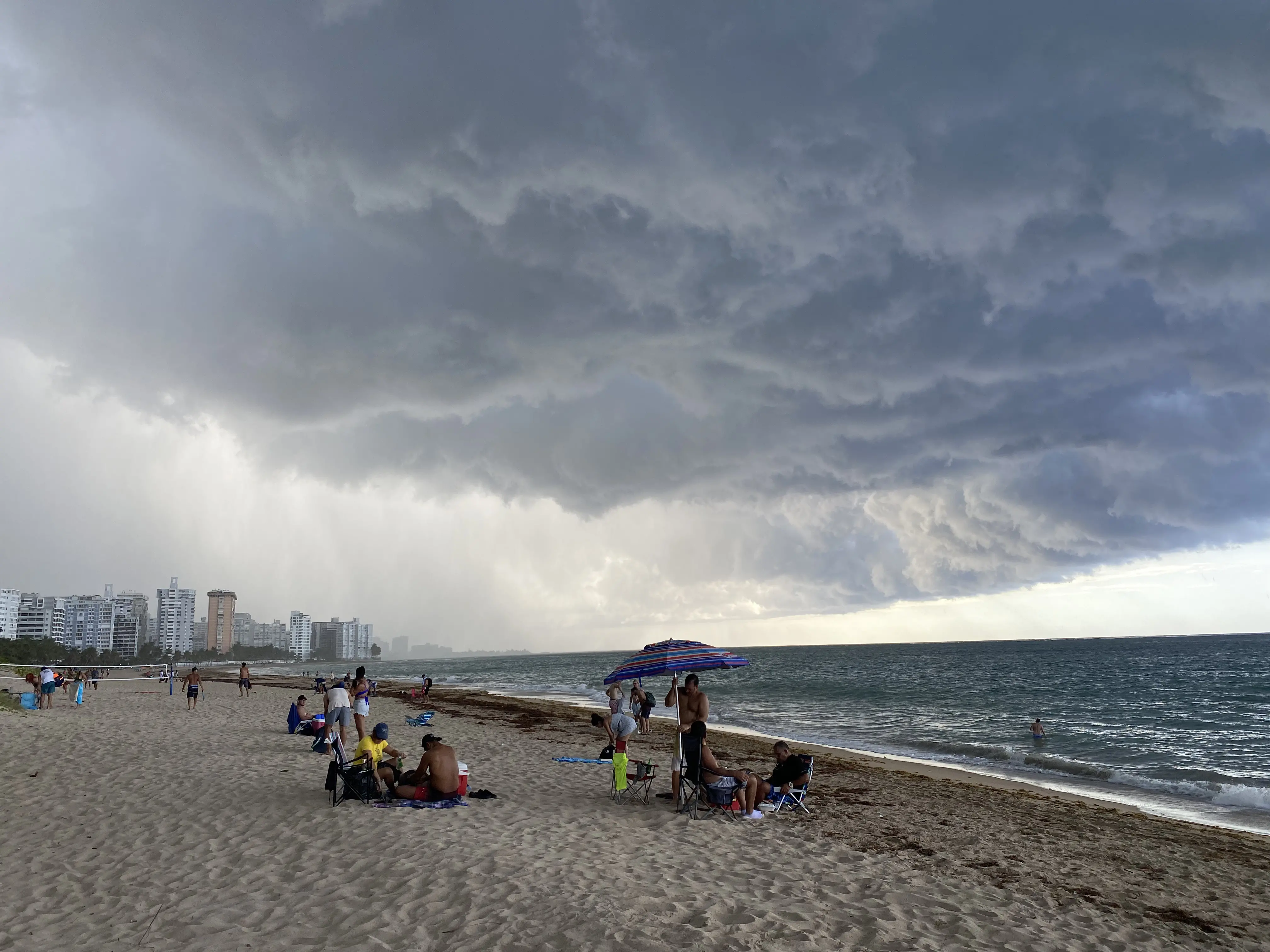 Clouds form overhead as an afternoon storm rolls in on Ocean Park beach in San Juan