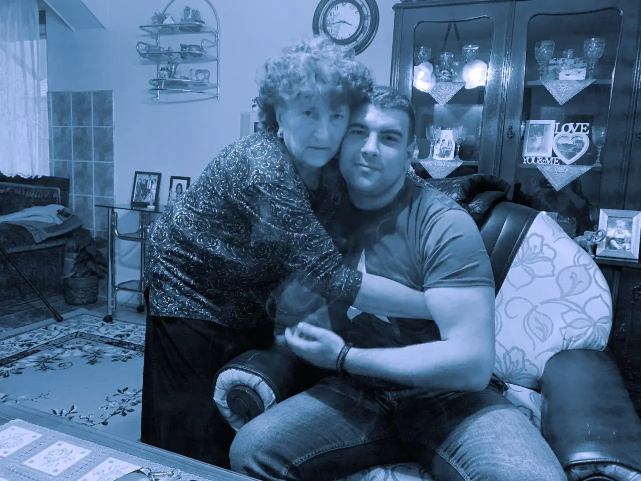 A mother and son photographed together in a living room.