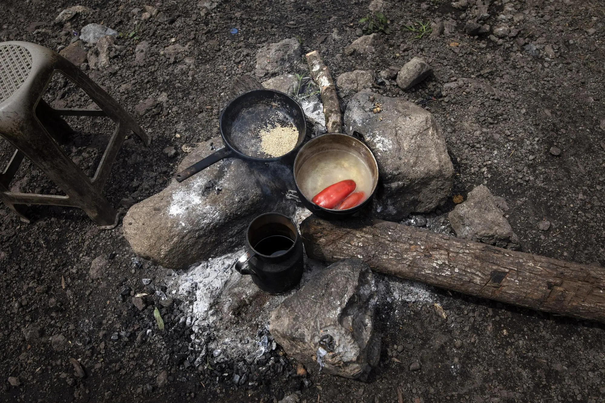 Pots with red chiles and sesame seeds on a stove