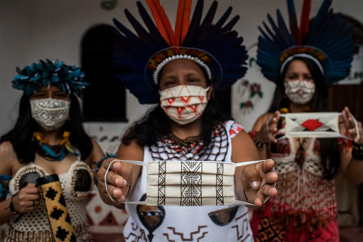 Indigenous women display face protection masks that they made for relatives and other communities.