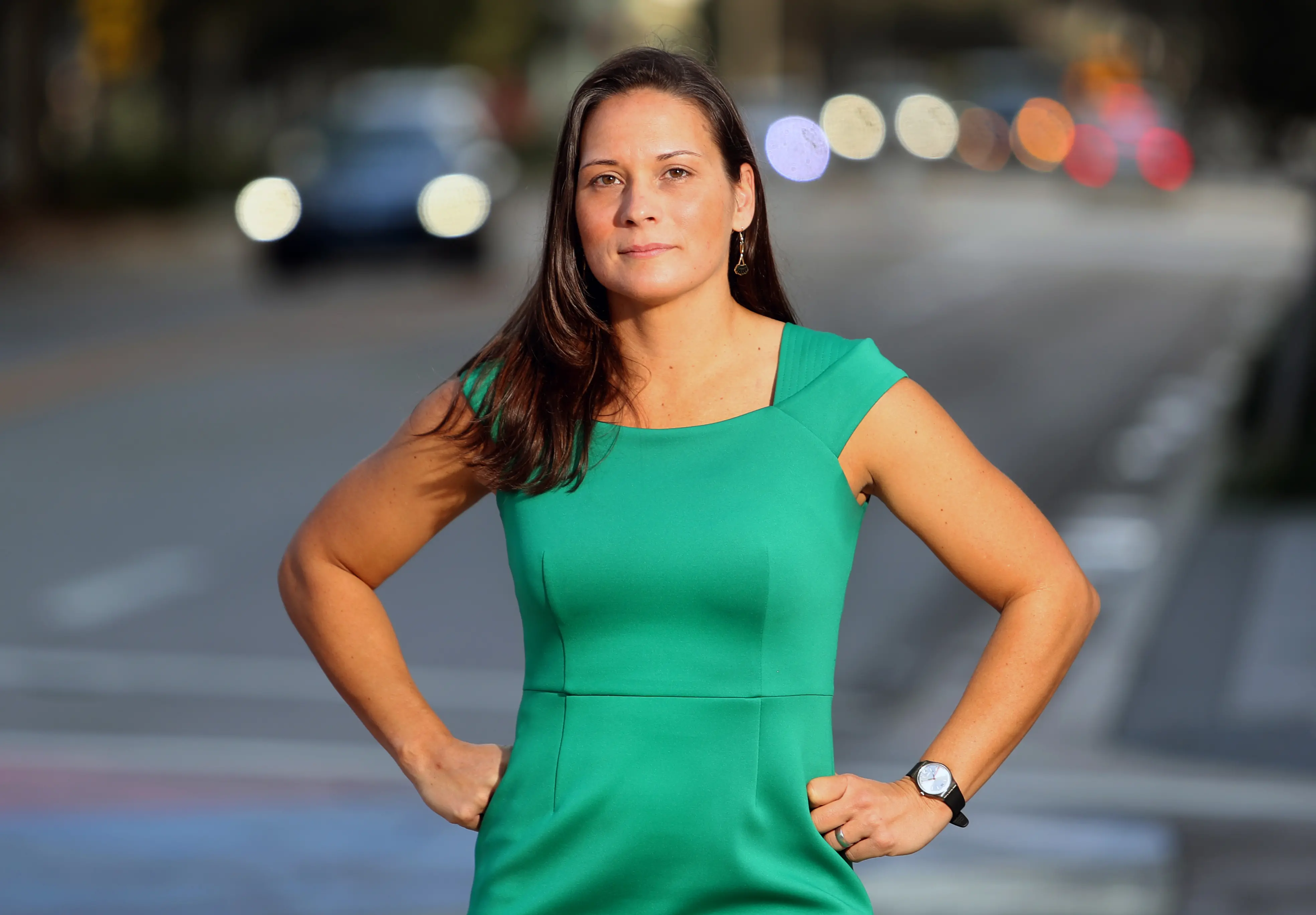 Headshot of attorney Christina Currie in a green dress at a street intersection