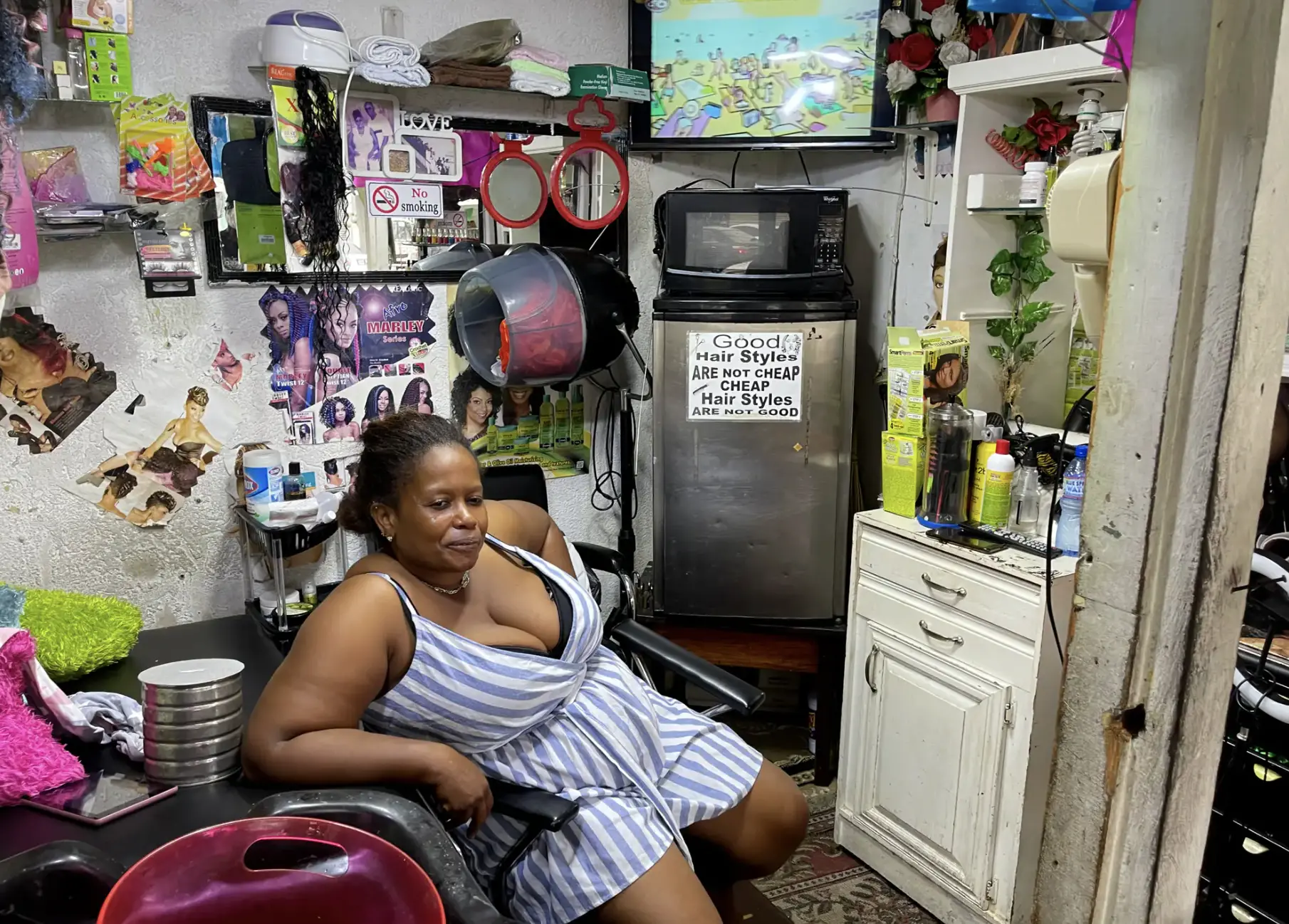 A woman sits in her hair salon