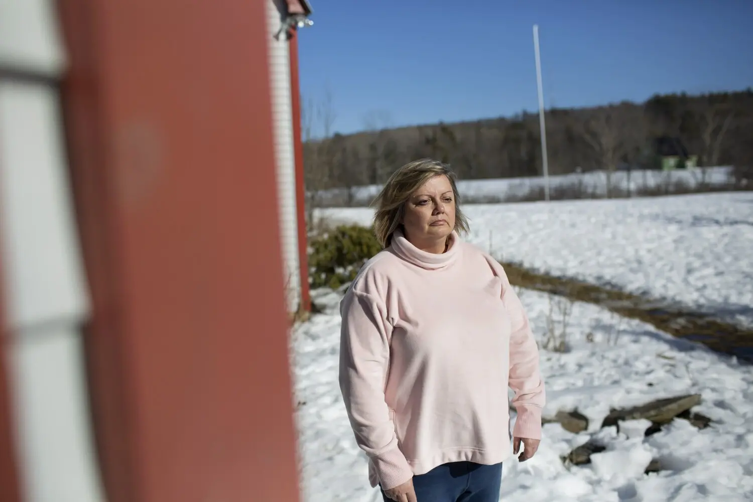 Amy Burns stands outside of her home, in a snowy yard.