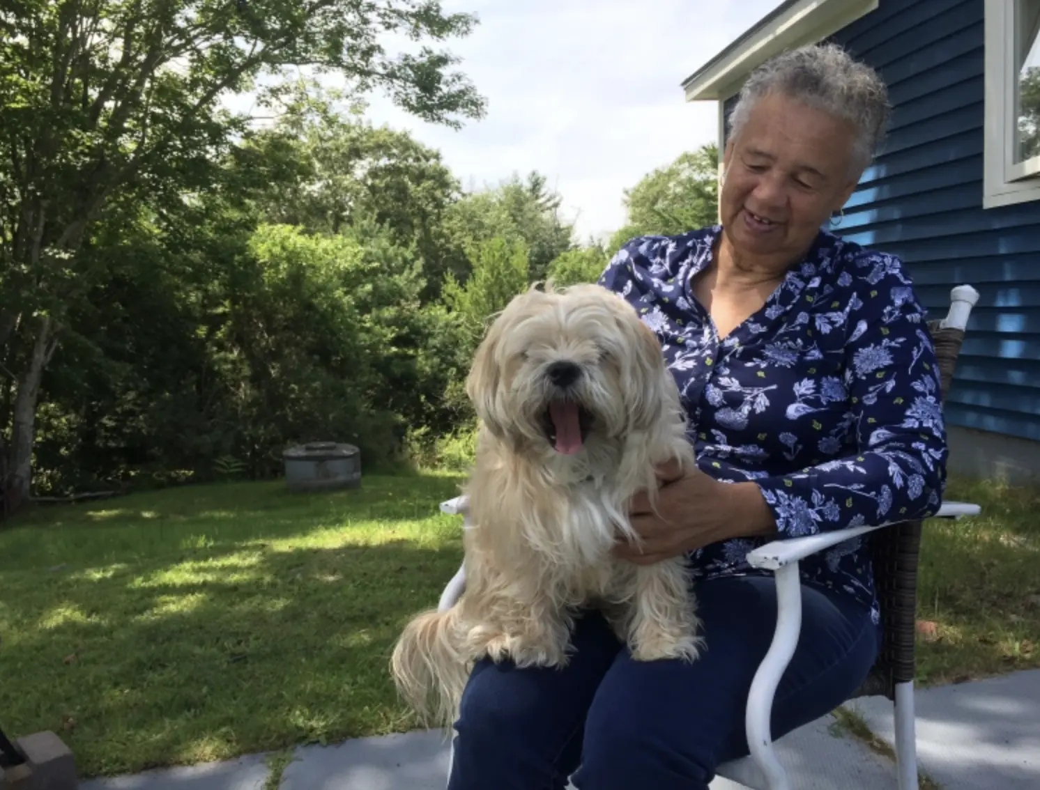 Woman holds dog in her backyard