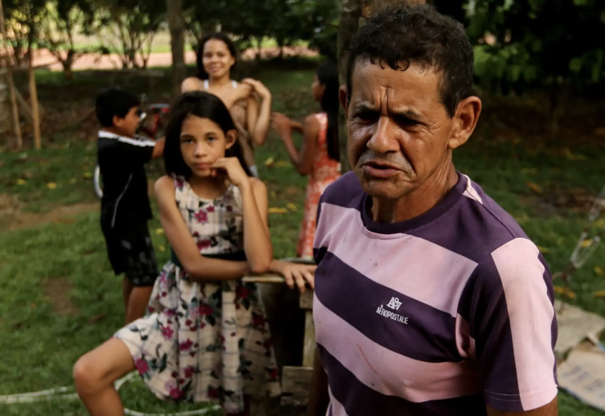 Aladino Oliveira da Costa, 60, and his daughter Darah Lady, 10, talk with a reporter outside their home