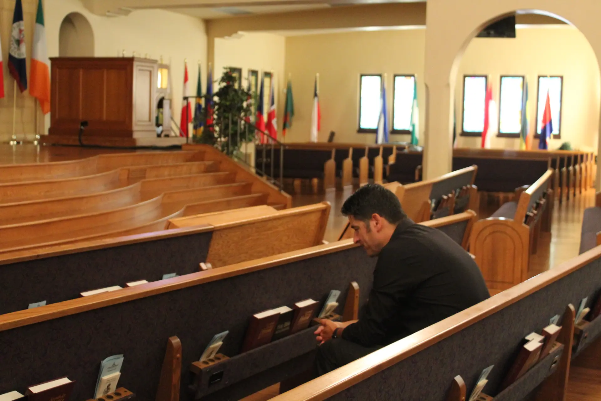 Man sits in church pew.