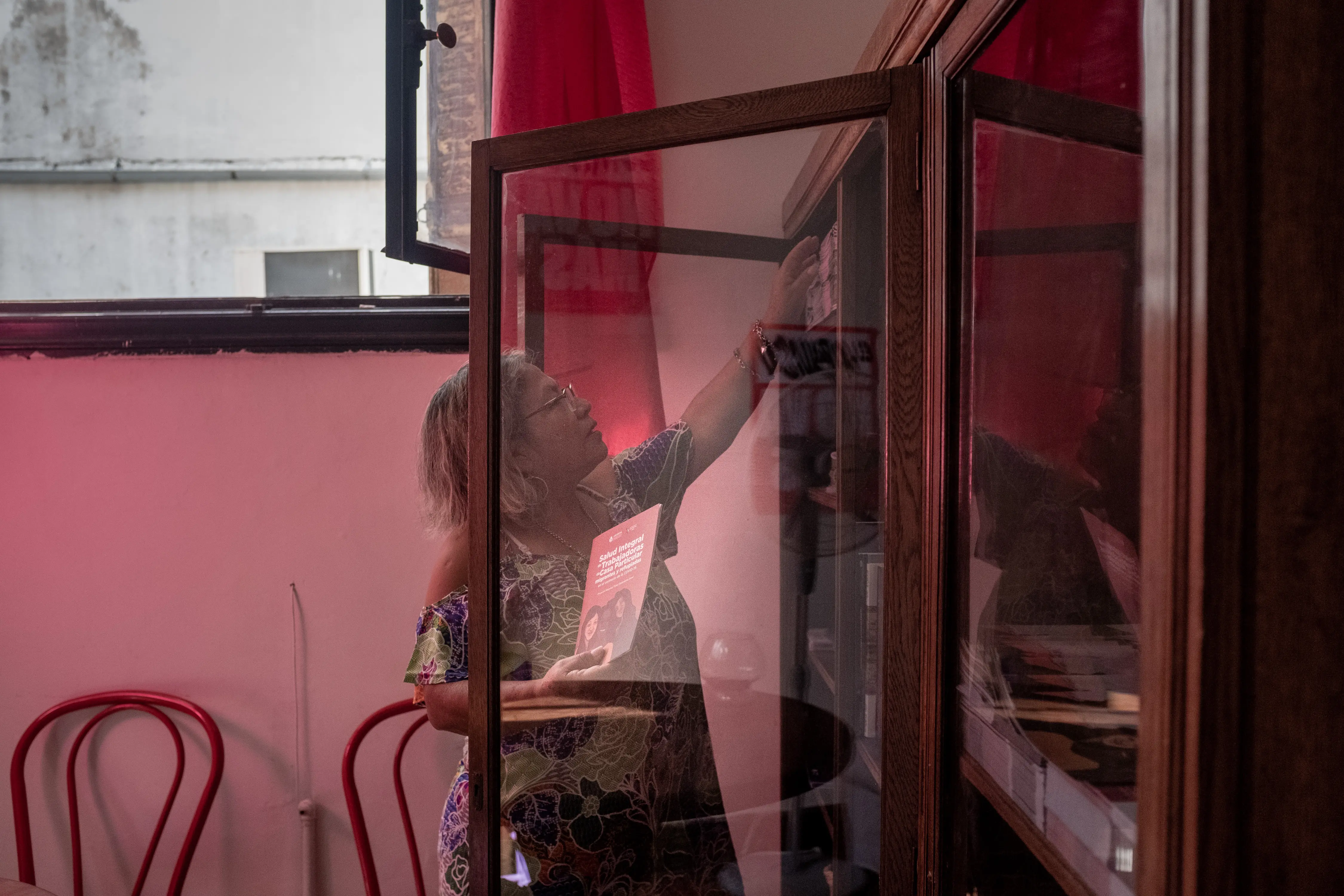 A person reaches for something on a shelf.