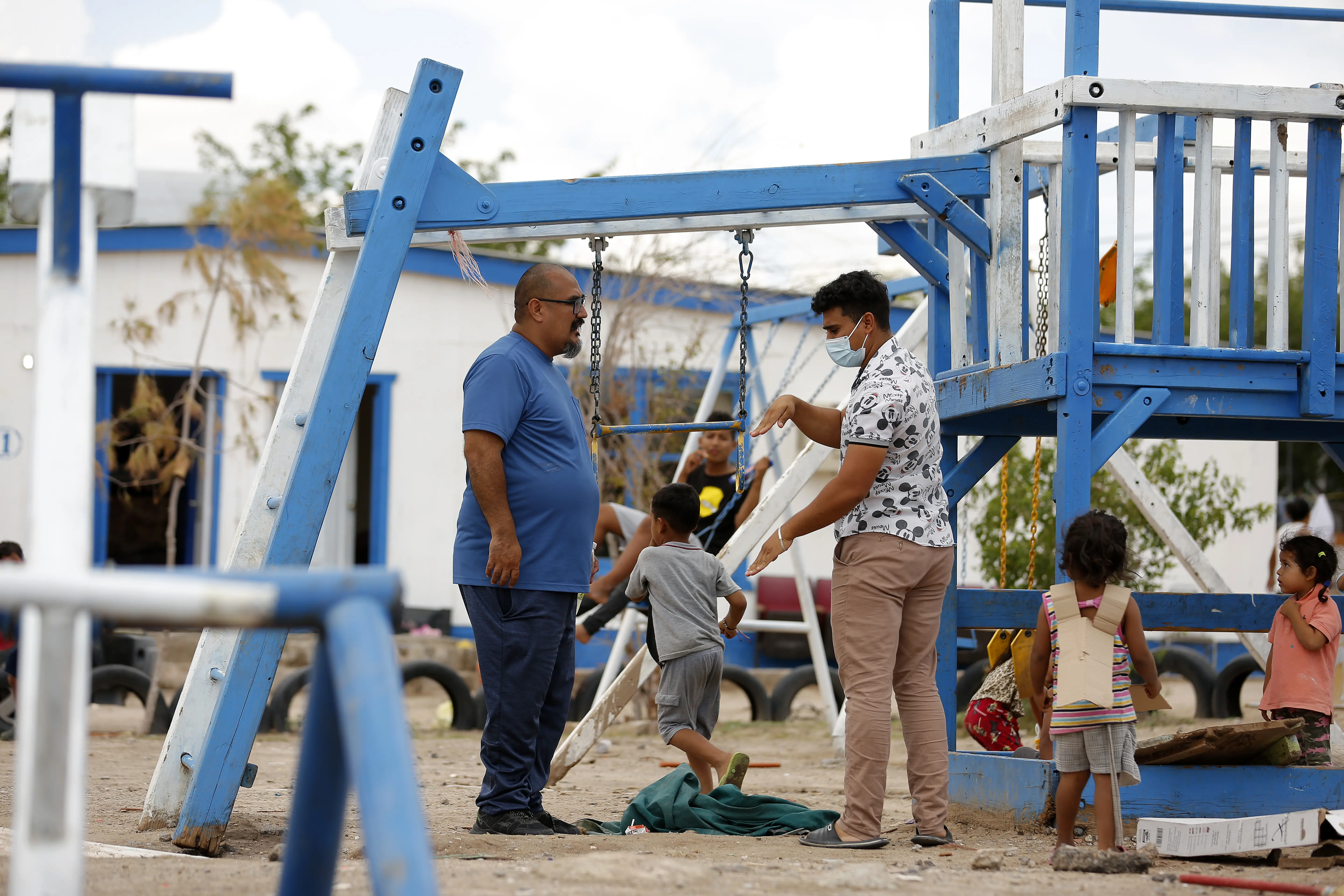 Juan Ortiz, left, discusses plans with a volunteer at the migrant shelter