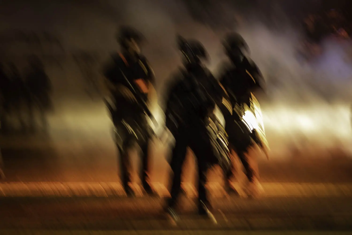 Portland Police officers in riot gear stand assembled amidst teargas after making numerous<br />
arrests on the night of September 29, 2020.