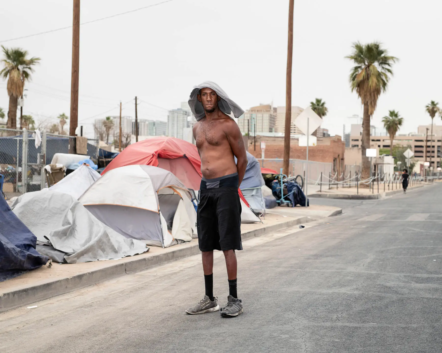 a man stands on street next tents