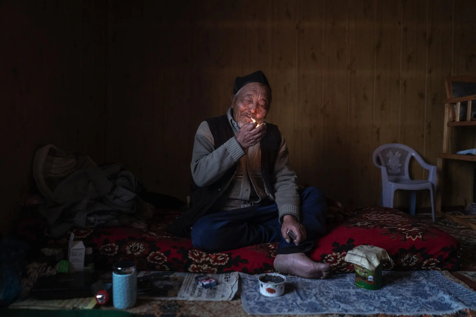 Man lights a cigarette on a blanket