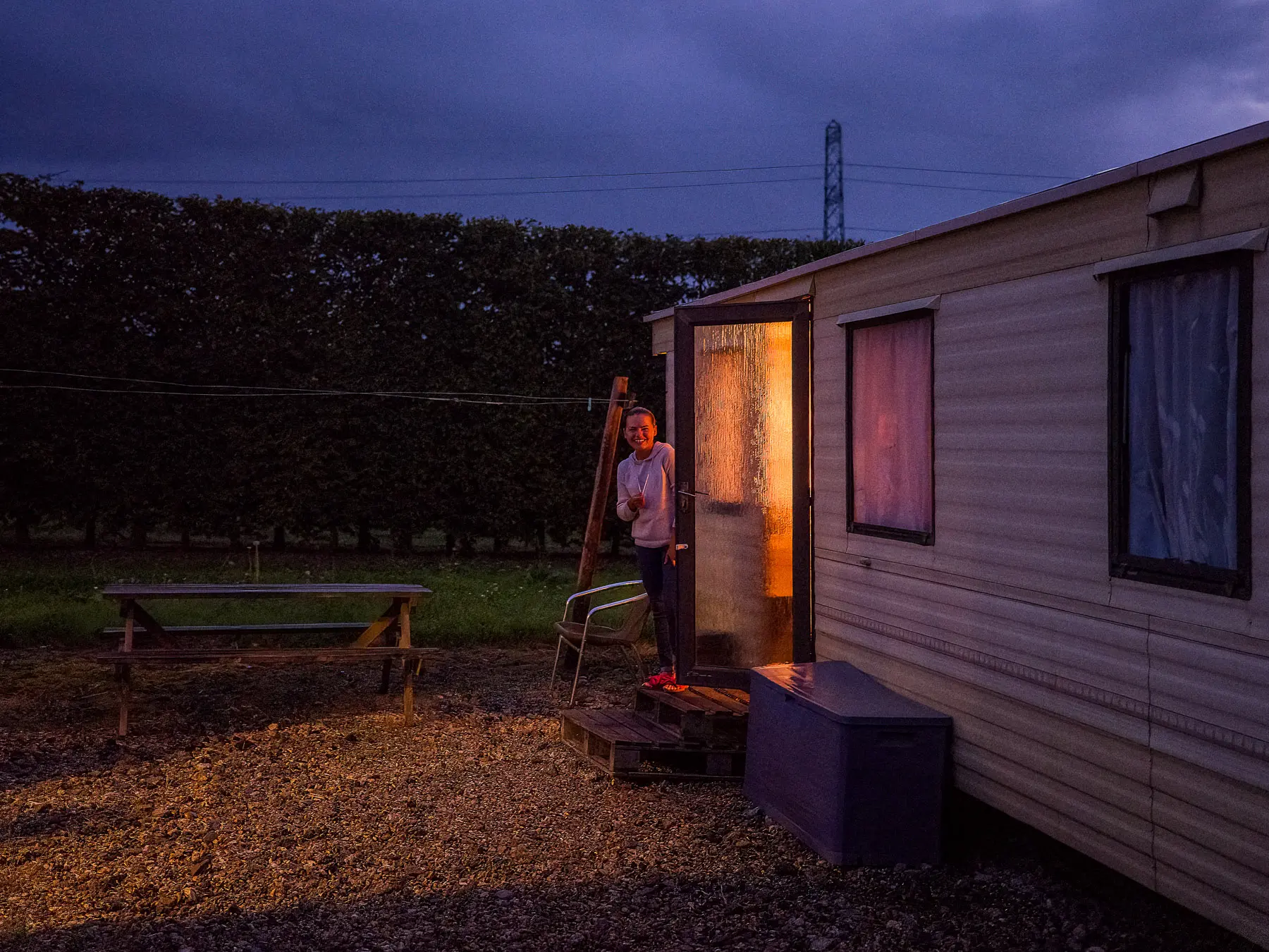 Young woman peeks out of a door of her caravan