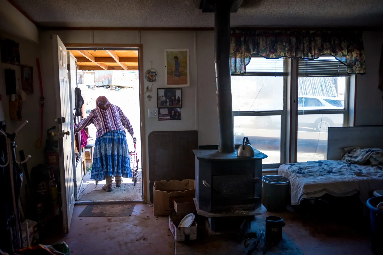 Helen Nez stands in a doorway, facing away from the camera. Image by Mary F. Calvert. United States, 2020.