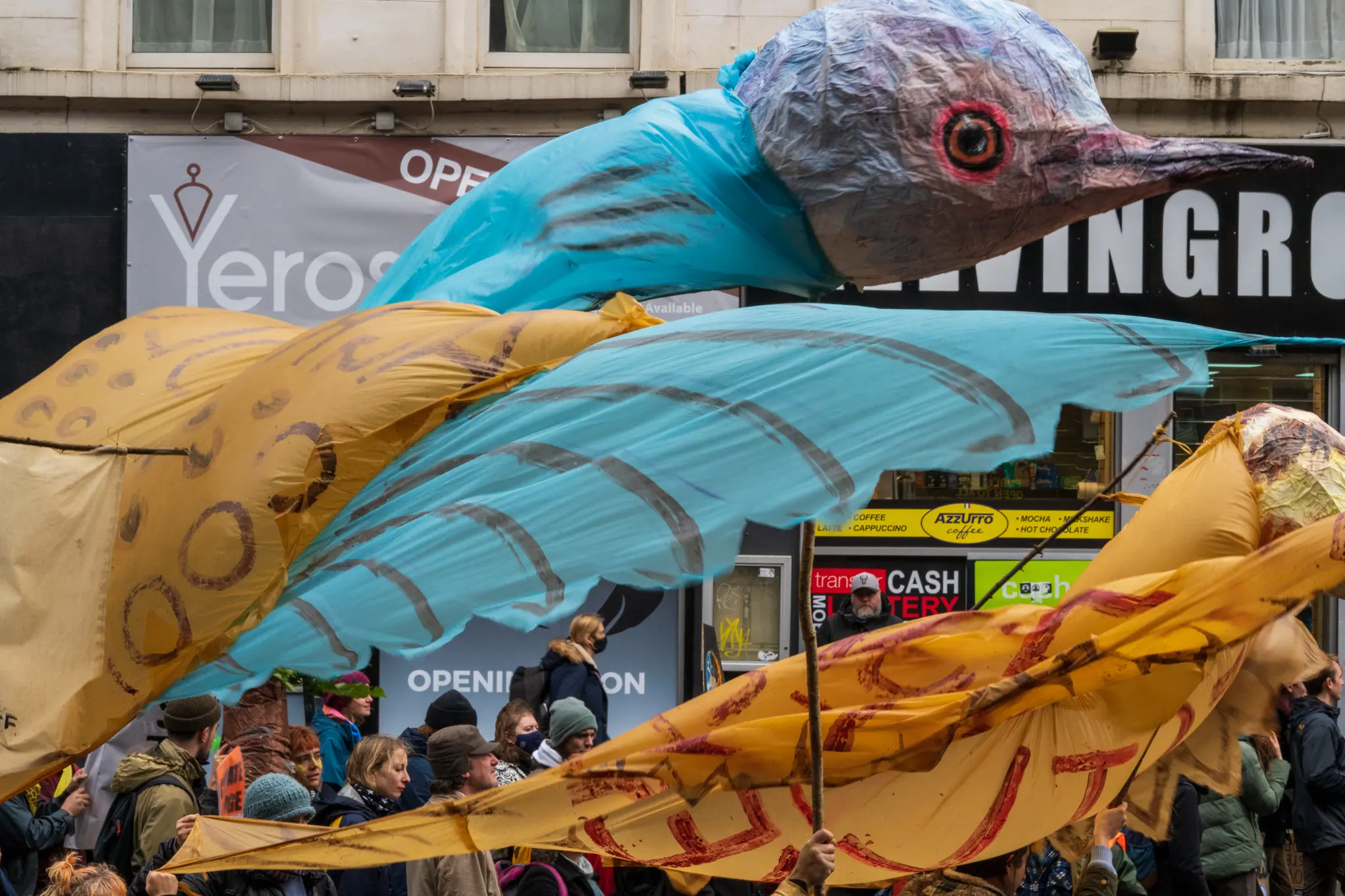 marchers hold a bird sculpture in the air