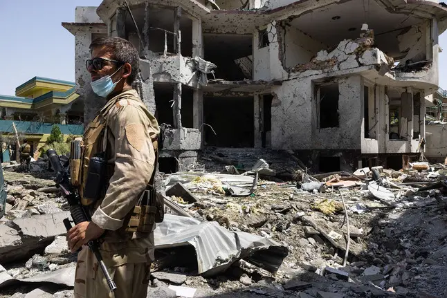 man stands in front of destroyed building