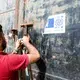 A guard at the Nasr detention center in Zawiya opens a prison door that boasts a sticker from the European Union and IOM. Image by Peter Tinti. Libya, 2017.