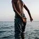 Musa prepares to jump in the water after his family's fishing trip. The group failed to catch any fish and returned to shore to retie their nets for the next day's excursion. Image by Alex Potter. Yemen, 2018.