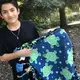 Carlos shows off a blanket he made with his mom. He chose the fabric with the guitars to reflect his love of music. His mom picked the sea turtles. Image by Jaime Joyce for TIME Edge. California, 2018.