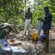 Chinko employees wash their clothes and other belongings in a stream near the park's main base. Image by Jack Losh. Central African Republic, 2018.