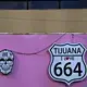 Signs advertise a tourist shop selling Tijuana-themed T-shirts, hats and souvenirs in Playas de Tijuana on Nov. 29. Image by Amanda Cowan. Mexico, 2019.