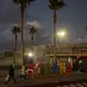 A man strolls past a Tijuana sign popular with tourists near the border wall at dusk in Playas de Tijuana on Nov. 29. Image by Amanda Cowan. Mexico, 2019.