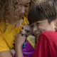 Kennedy Flores and her brother, Edward, cuddle with family dog, Bambi, as they visit their father for the Thanksgiving holiday in Tijuana, Mexico. Image by Amanda Cowan. Mexico, 2019.