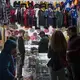 Raymond Flores looks to his father, Ramon, right, for approval as he shops for his birthday present with his siblings along Avenida Revolucion in Tijuana, Mexico. The chain costs 750 pesos, which is approximately $38. Ramon, who makes around $110 a week, said he wanted him to have the gift. 'When I get the opportunity to give them something they want, I feel good,' he said. Image by Amanda Cowan. Mexico, 2019.