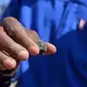 A South African, small-scale miner displays gold ore his operation dug out of a mine at the heritage park marking the discovery of gold on the Witwatersrand Basin. Image by Mark Olalde. South Africa, 2017.