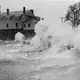 1938: Waves crashed against the Woods Hole Great Harbor waterfront and the old United States Fish Commission building during the hurricane. Image courtesy of Woods Hole Historical Museum Archives. United States, 1938.