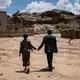 Salah and Yahya hold hands as they walk through a historic site near their home. Image by Alex Potter. Yemen, 2018.