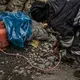 A worker laboring without any protection uses a blow torch with a flame so hot that it is invisible. It vaporizes mercury used to isolate gold from ore. Peru, 2019. Image by James Whitlow Delano.