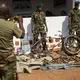 Two rangers pose for a photo next to machetes, knives, spades and other equipment which have been confiscated from poachers and laid out at Chinko’s HQ. Image by Jack Losh. Central African Republic, 2018.