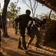 Rangers frogmarch suspected poachers to a holding cell at the park’s main base. Three days later, Chinko’s management will be left with no choice but to pay for a helicopter that will take the group to the capital and transfer them into CAR’s justice system. Image by Jack Losh. Central African Republic, 2018.