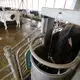 Cows are trained to stand inside a robotic milker, which handles cleaning, milking and record-keeping. Image by Mark Hoffman. Canada, 2019.