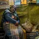 A resident, bundled up against the constant Andean cold, sits in her food stall in the gold-processing area. This part of La Riconada is most acutely contaminated with mercury, which condenses on everything after being vaporized during the gold-purification process. Peru, 2019. Image by James Whitlow Delano.