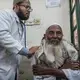 A lung specialist listens to the raspy breathing of a patient. Dr. Wahid says asthma is the most common pollution-related disease he sees. Image by Larry C. Price. Bangladesh, 2018.