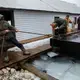 Dock builders from North Shore Docks secure a barge at Patrick's Landing at Les Cheneaux Islands in the Upper Peninsula of Michigan on Nov. 20, 2019. Image by Zbigniew Bzdak / Chicago Tribune. United States, 2020.