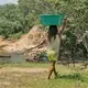 A young girl walks beside the Parguaza River. While indigenous men mostly work as miners, indigenous women are also an integral part of mining activities, working as miners, doing laundry, serving as cooks, maids and prostitutes. Image by Bram Ebus. Venezuela, 2017.