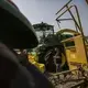 A man walks between a John Deere combine and tractor on display during the groundbreaking of the China-US Demonstration Farm on Saturday, Sept. 23, 2017, in Luanping County, Hebei. Kelsey Kremer. 